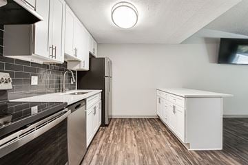 Woodstock apartment for rent - A kitchen with white cabinets and a black refrigerator.