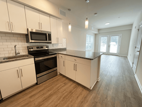 Concord apartment for rent - A kitchen with white cabinets and a black microwave at Emery Village, Concord, NC