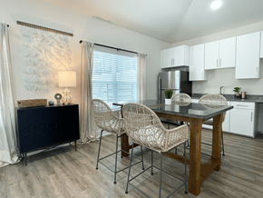 Concord apartment for rent - A kitchen with a table and chairs in the foreground and a refrigerator in the background at Emery Village, Concord, NC