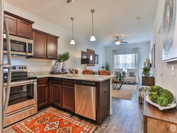 Bloomingdale apartment for rent - A kitchen with wooden cabinets and a rug on the floor.
