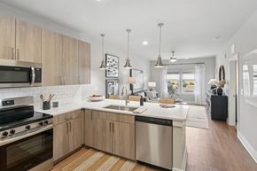 Fort Myers apartment for rent - A modern kitchen with wooden cabinets and stainless steel appliances at The Hendry Apartments, Fort Myers