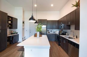 Austin apartment for rent - a large kitchen with a white island and dark cabinets at The Monroe Apartments, Austin, 78741