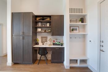 A home office with a desk and a refrigerator