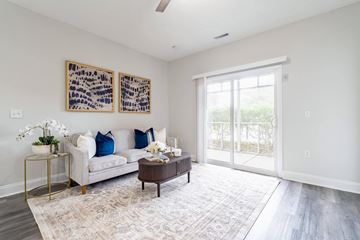 Moncks Corner apartment for rent - A living room with a white couch, a coffee table, and two paintings on the wall.