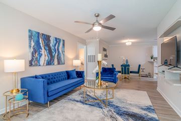 Covington apartment for rent - A living room with a blue sofa and a painting on the wall.