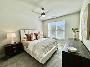 Atlanta apartment for rent - A bedroom with a large bed, a ceiling fan, and a nightstand with a lamp at The Collective Upper Westside Apartments, Atlanta, 30318