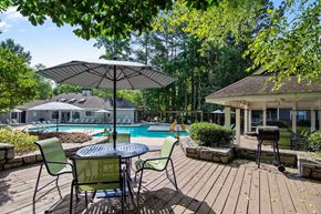 Stone Mountain apartment for rent - A pool area with a table and chairs and umbrellas.