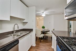 Stone Mountain apartment for rent - A kitchen with white cabinets and a black dishwasher.