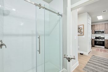 A glass shower door in a white bathroom.