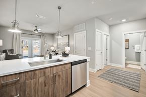 Kennesaw apartment for rent - A modern kitchen with wooden cabinets and stainless steel appliances at The Ashton at East Park Apartments, Kennesaw, GA