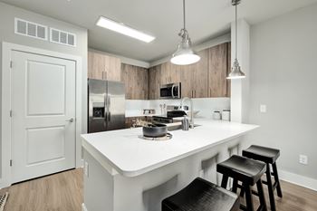 A kitchen with a white countertop and black stools.