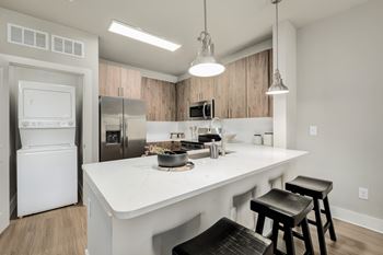 A modern kitchen with a white countertop and black bar stools.