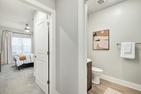 Kennesaw apartment for rent - A white bathroom with a toilet, sink, and a bedroom with a bed and window at The Ashton at East Park Apartments, Kennesaw, Georgia