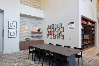 A conference room with a long table and chairs and a bulletin board on the wall