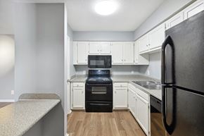 Huntsville apartment for rent - A kitchen with a black refrigerator and white cabinets  at Governors House, Huntsville, 35805