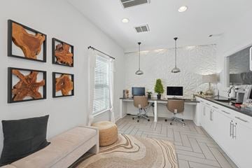 Wilmington apartment for rent - A modern living room with a couch, a desk with a computer, and three abstract paintings on the wall.
