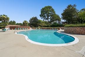 Charleston apartment for rent - A large outdoor swimming pool with a white border and a white concrete edge.