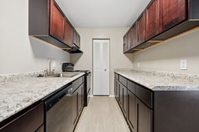 Charleston apartment for rent - A kitchen with dark brown cabinets and granite countertops.