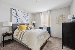 Aiken apartment for rent - A bedroom with a large bed and a painting on the wall.