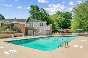 Charlotte apartment for rent - A swimming pool in a residential area with a house in the background.