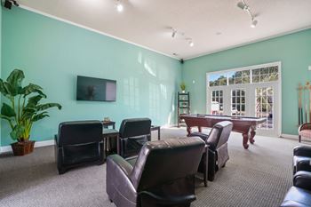 Living room with a pool table and chairs