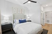 Atlanta apartment for rent - A bedroom with a large bed, a ceiling fan, and a nightstand with a lamp at Union Eleven Apartments, Atlanta, 30324