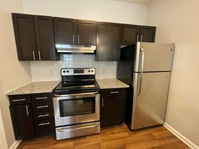 Burlington apartment for rent - Kitchen with stainless steel appliances and black cabinets at The Chase, Burlington, NC