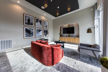 A living room with a red couch and a tv