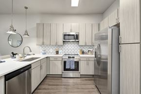 Nashville apartment for rent - A modern kitchen with stainless steel appliances and wooden cabinets at The Percy Apartments, Nashville, 37214