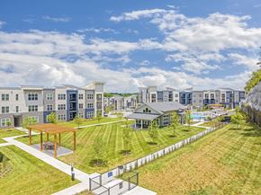 Nashville apartment for rent - A large building complex with a playground in the foreground at The Percy Apartments, Nashville, 37214