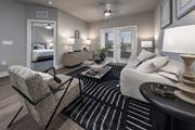 Winter Haven apartment for rent - A well-lit bedroom with a large bed, a chair, and a coffee table at The Waverly at Winter Haven Apartments, Florida