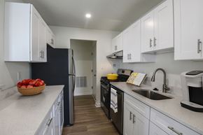 Landover Hills apartment for rent - A kitchen with white cabinets and a black refrigerator.
