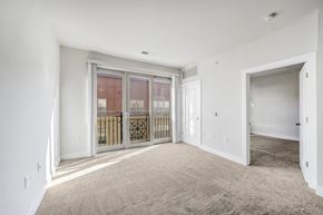 Washington apartment for rent - A spacious room with a carpeted floor and a sliding glass door.