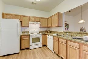 Martinsburg apartment for rent - a kitchen with white appliances and wooden cabinets