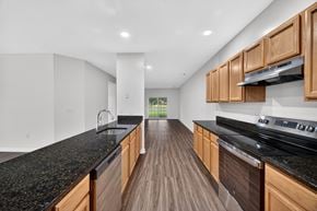 Martinsburg townhouse for rent - A modern kitchen with wooden cabinets and black countertops.