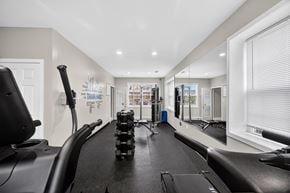 Martinsburg townhouse for rent - A treadmill is in a spacious gym with a mirrored wall.