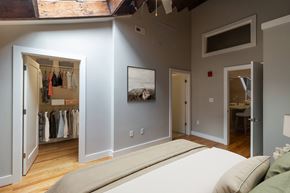 Richmond apartment for rent - A bedroom with a large bed and a closet with clothes hanging.