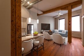 Richmond apartment for rent - A modern kitchen with white chairs and a wooden floor.