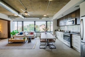 Falls Church apartment for rent - A modern kitchen with a dining table and chairs in the middle of the room.