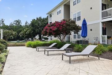 Lexington Park apartment for rent - A patio with two lounge chairs and a table with a blue umbrella.