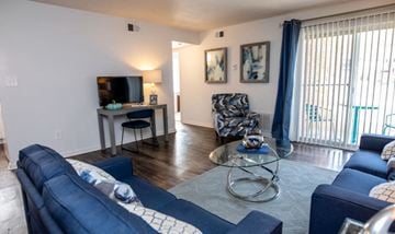 Newport News apartment for rent - a living room with blue couches and a glass coffee table