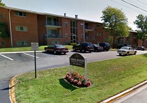 College Park apartment for rent - A sign for the Ferms Manor apartment complex stands in front of a parking lot.