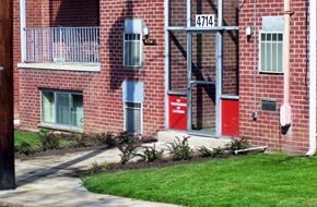 College Park apartment for rent - A red door with a sign that says "No Parking" is on the side of a brick building.