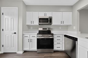 Great Mills apartment for rent - A kitchen with white cabinets and appliances.