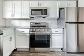 Virginia Beach apartment for rent - a kitchen with white cabinets and stainless steel appliances