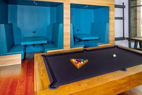 Alexandria apartment for rent - A pool table with a wooden frame and a black felt cloth is in the center of the room.