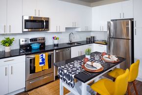 Alexandria apartment for rent - A modern kitchen with a black and white patterned table and yellow chairs.