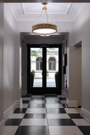 Richmond apartment for rent - A hallway with black and white checkered flooring and a chandelier hanging from the ceiling.