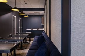 Richmond apartment for rent - A modern dining area with dark walls and blue couches.