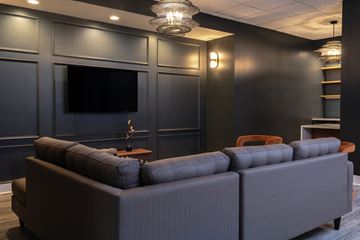 Richmond apartment for rent - A modern living room with a grey sofa and a flat screen TV mounted on the wall.